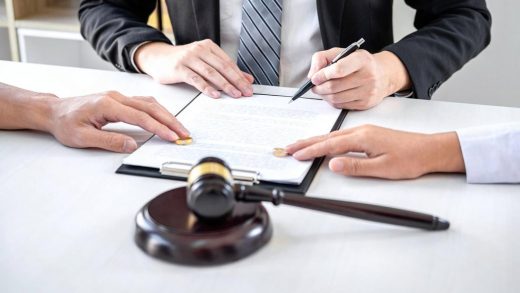 Divorce lawyer in Dubai signing separation papers with wedding rings and a gavel on the desk
