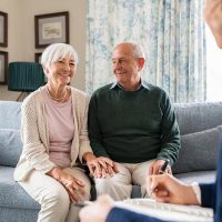 Senior couple meeting a financial advisor in the UAE to review a life insurance policy