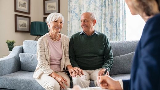 Senior couple meeting a financial advisor in the UAE to review a life insurance policy
